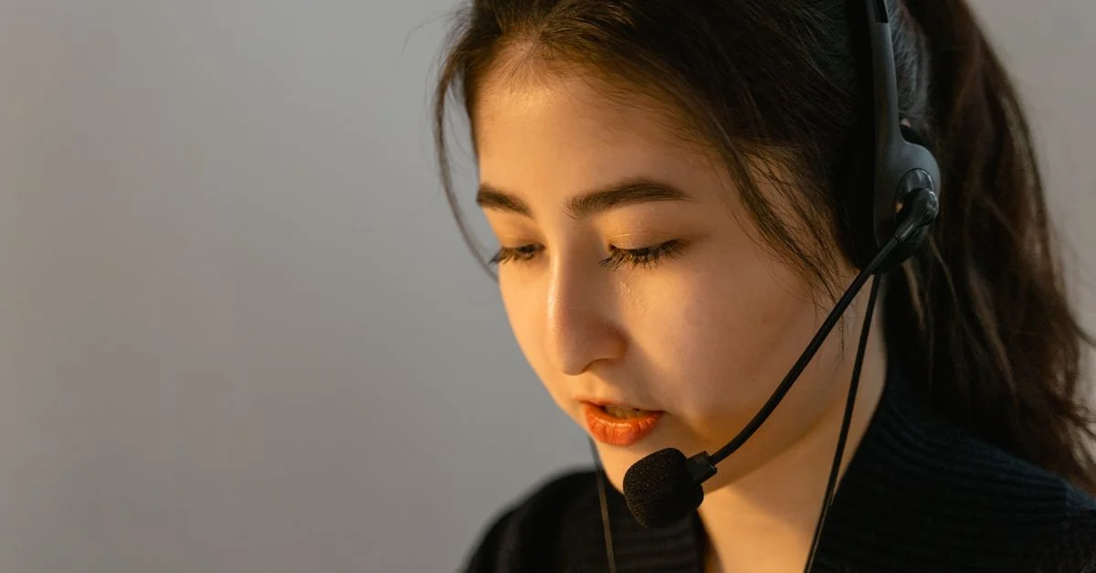 Jeune femme concentrée avec un casque travaillant dans le support client, parlant attentivement.
