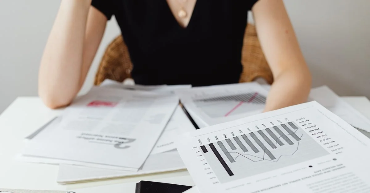 Gros plan de documents financiers et de graphiques sur un bureau, illustrant une analyse commerciale.