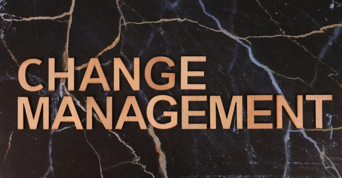 Des lettres en bois formant l'inscription « Gestion du changement » sur une surface en marbre foncé, soulignant le changement au sein de l'entreprise.